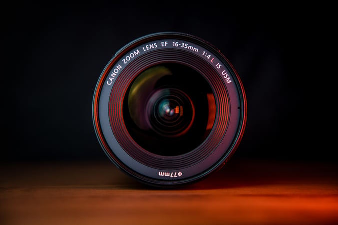 black-camera-lens-brown-wooden-table-1